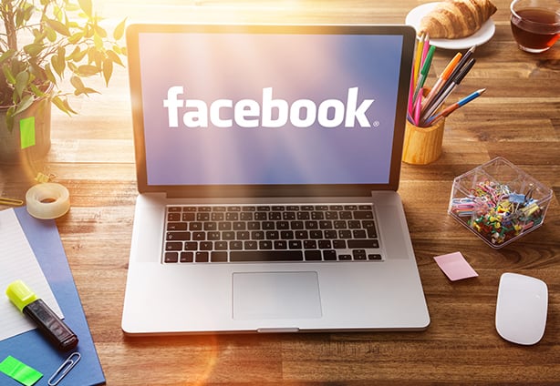Office workplace with facebook screen. PRAGUE, CZECH REPUBLIC - FEBRUARY 20, 2014: Facebook is an online social networking service founded in February 2004 by Mark Zuckerberg with his college roommates and is now a fortune 500 company.