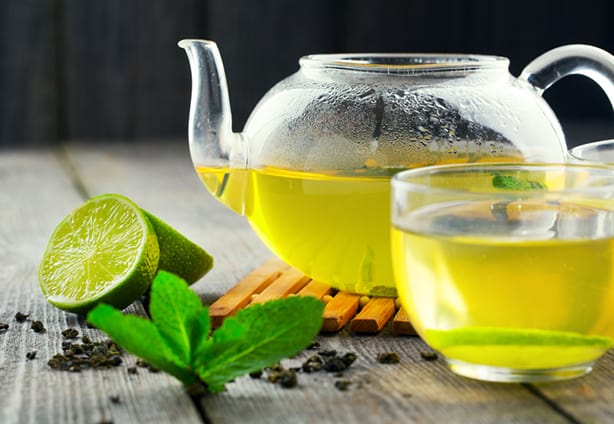 Green Tea Mug of green tea and teapot on wood table